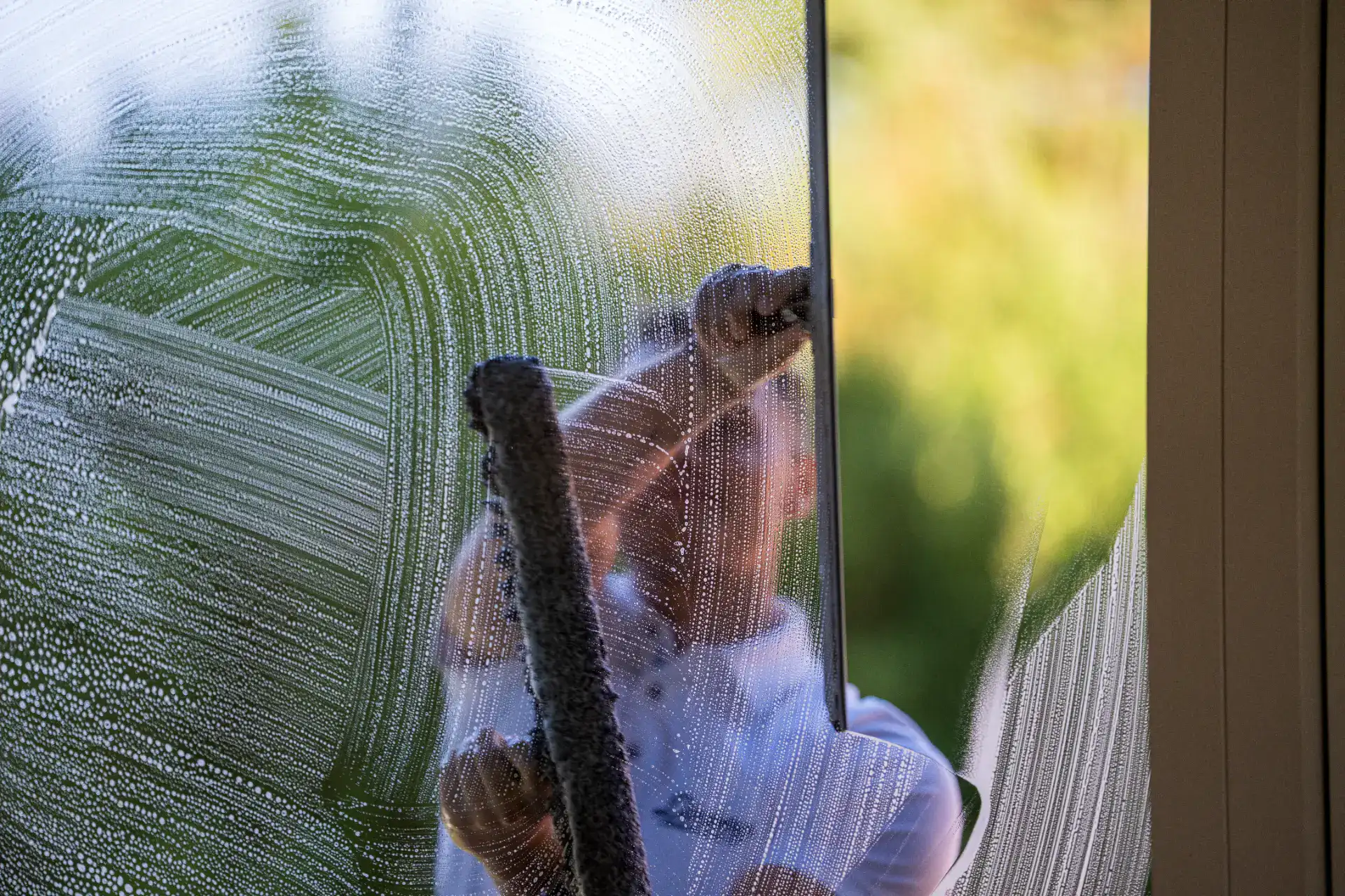 Professionel vinduespudsning af store vinduer med fokus på klarhed og glans.