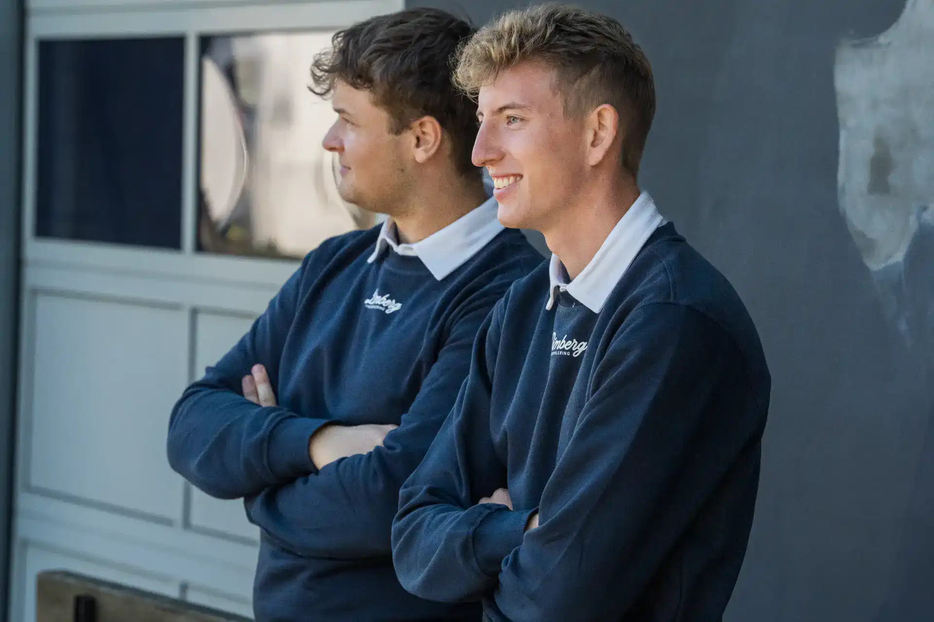 To professionelle vinduespudsere står klar til at rense vinduer.