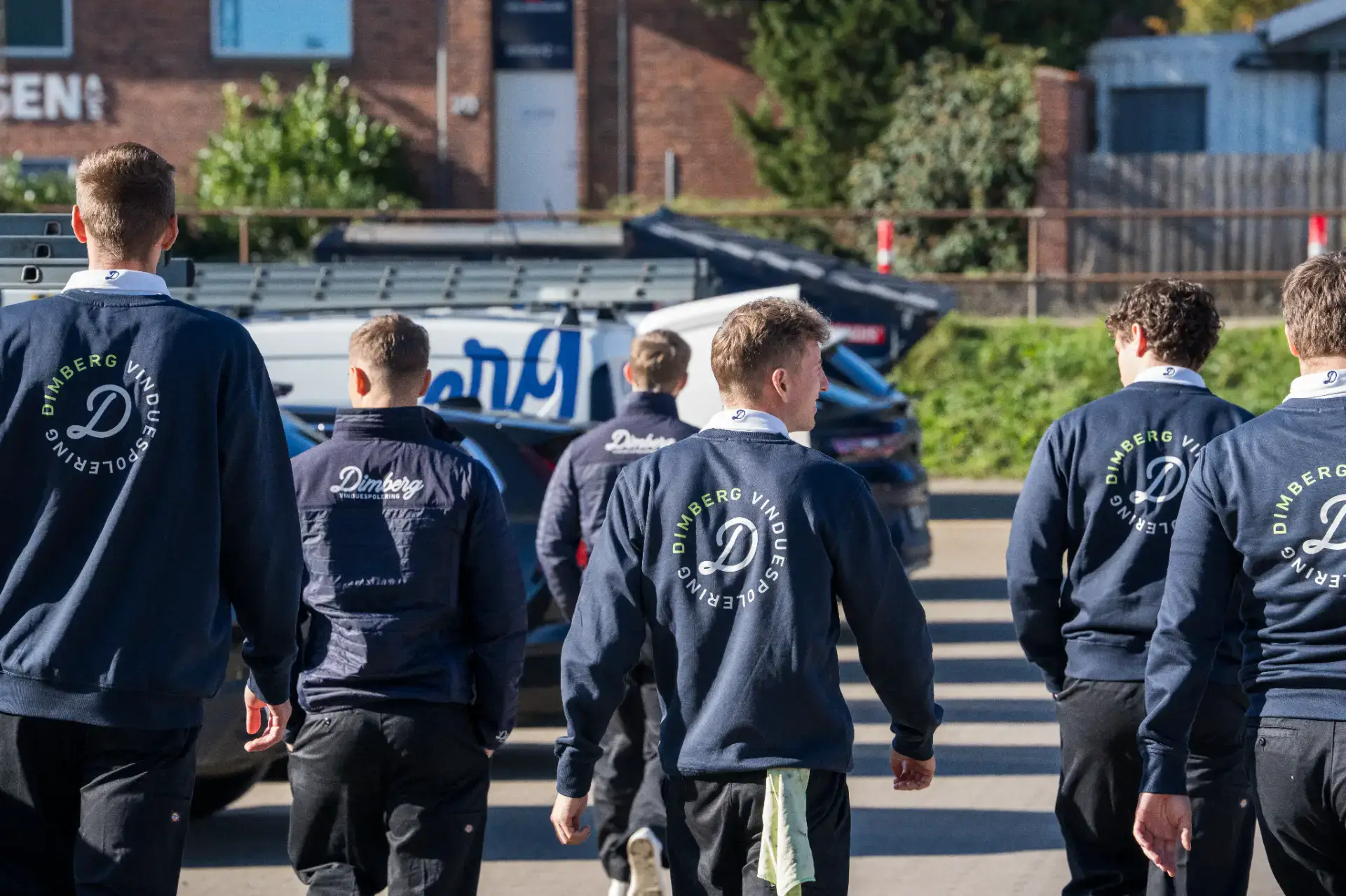 Team af professionelle vinduespudsere klar til at rense store vinduer.