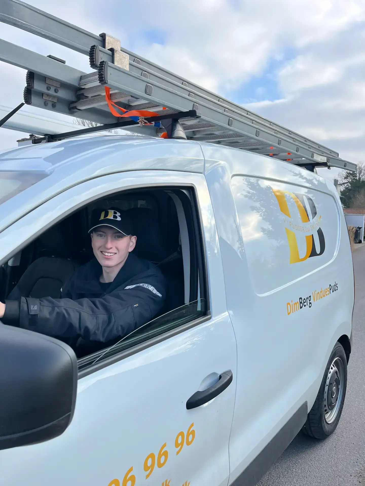 Professionel vinduespudser i servicebil klar til at rense vinduer.